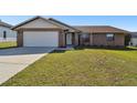 Brick house with a two-car garage and well-maintained lawn at 3220 Cherry Hill S Cir, Lakeland, FL 33810