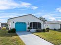 Front view of a white house with teal garage door, landscaping, and driveway at 3273 Pebble Bend Dr, Lakeland, FL 33810