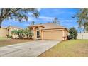 Front view of a tan house with driveway at 3445 Sleepy Hill Oaks St, Lakeland, FL 33810