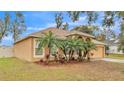 Tan house with palm trees and landscaping at 3445 Sleepy Hill Oaks St, Lakeland, FL 33810