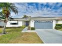 Single-story home with a gray roof, attached garage, and landscaped yard at 3618 Highland Fairways Blvd, Lakeland, FL 33810