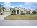 Tan house with a welcoming front porch and lush green grass at 4009 Oakley Way, Lakeland, FL 33813