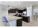 Modern kitchen with dark cabinets, granite countertops, and stainless steel appliances at 4179 Oaktree Dr, Davenport, FL 33837