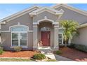 Front entrance with a red door and palm trees at 4308 Whistlewood Cir, Lakeland, FL 33811