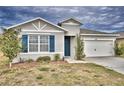 One-story home with gray siding, blue shutters, and a two-car garage at 442 Jacks Way, Davenport, FL 33837