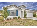 One-story house with gray siding, blue shutters, and a two-car garage at 442 Jacks Way, Davenport, FL 33837