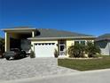 House exterior view featuring a two-car garage and palm trees at 593 Meandering Way, Polk City, FL 33868