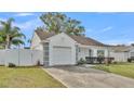 Front view of a single-story house with a white exterior, gray accents, and a spacious lawn at 6111 Morningview Dr, Lakeland, FL 33813