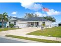 Modern house with a two-car garage and American flag at 1427 Magnolia Ln, Auburndale, FL 33823