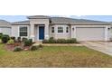 Front view of a house with a blue door and attached garage at 155 Kissengen Park Blvd, Bartow, FL 33830