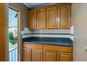 Dark-countertop kitchen with wood cabinets and tiled backsplash at 1801 Quail Hill Dr, Lakeland, FL 33810