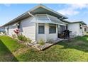 Patio area with green grass, white siding and trim, plus an awning and mature plants at 1847 Masters Ln, Lakeland, FL 33810