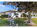 Exterior showcasing well-maintained landscaping, a mature shade tree, and clean white siding at 1847 Masters Ln, Lakeland, FL 33810