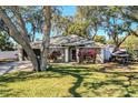 Charming house with mature trees, a well-manicured lawn, and a boat at 2227 Howard West Ave, Winter Haven, FL 33880