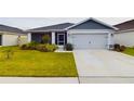 Charming home features a large driveway, an attached two-car garage, and manicured landscaping at 2610 San Marco Way, Winter Haven, FL 33884