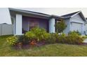 Landscaped front yard includes flowering bushes, trees, and green grass at 2610 San Marco Way, Winter Haven, FL 33884