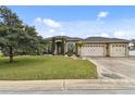 House exterior showcasing a three-car garage and lush green lawn at 2774 Verandah Vue Way, Lakeland, FL 33812