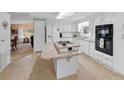 White kitchen with breakfast bar, stainless steel appliances, and view into dining area at 3221 Pebble Bend Dr, Lakeland, FL 33810