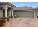 Gray garage door with paver driveway and landscaping at 3604 Frentress Dr, Lakeland, FL 33812