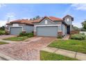 Two-story home with gray exterior, tile roof, and brick paver driveway at 4108 Solamor St, Lakeland, FL 33810