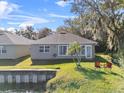 Back of house with lake access and seating at 4481 Pebble Pointe Dr, Lakeland, FL 33813