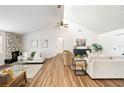 Bright living room featuring vaulted ceilings, stone fireplace, hardwood floors, and comfortable neutral furnishings at 4718 Valley Hill Ct, Lakeland, FL 33813