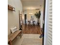 Bright entryway with wood floors, a bench, and views into the dining area at 5269 Pebble Beach Blvd, Winter Haven, FL 33884