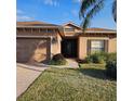 House exterior showcasing a two-car garage, walkway, and landscaping at 5269 Pebble Beach Blvd, Winter Haven, FL 33884