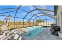 Screened in pool with chairs and patio furniture overlooking private backyard space at 5440 Siltstone St, Lakeland, FL 33811