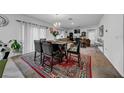 Bright dining area with dark wood table and chairs, view to living room at 5557 Oro Valley Rd, Auburndale, FL 33823