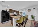 Modern kitchen with dark cabinets, granite countertops, and island with seating at 5557 Oro Valley Rd, Auburndale, FL 33823