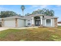 Curb appeal of a single-story home with stone accents and a two-car garage at 5819 Driftwood Dr, Winter Haven, FL 33884