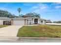 One-story house with a gray exterior, stone accents, and a landscaped lawn at 5819 Driftwood Dr, Winter Haven, FL 33884