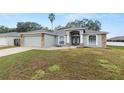 Landscaped yard with a single-story house featuring a gray exterior and stone accents at 5819 Driftwood Dr, Winter Haven, FL 33884