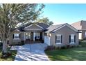 One story house with tan exterior, dark shutters, and a large driveway at 5825 High Ridge Loop, Lakeland, FL 33812