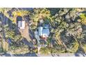 An aerial view showing a house, detached structure, and large lot with trees at 7030 Klein Rd, Lakeland, FL 33813