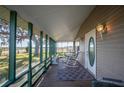 Relaxing screened porch with rocking chairs, offering a view of the yard at 7275 Lake Hendry Rd, Fort Meade, FL 33841