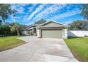 Green house with a two-car garage and a well-maintained lawn at 781 Sagewood Dr, Lakeland, FL 33813