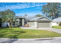 House exterior showcasing a green facade, driveway, and landscaping at 781 Sagewood Dr, Lakeland, FL 33813