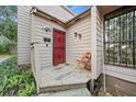 Quaint front porch with a red door and a rustic wooden deck at 1005 Shadow Run Dr, Lakeland, FL 33813