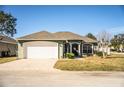 Green house with white garage door and well-manicured lawn at 1012 Robin Ln, Winter Haven, FL 33884