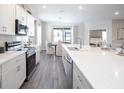 Modern kitchen with white cabinets, quartz countertops, stainless steel appliances, and an island at 1104 Mountain Flower Ln, Davenport, FL 33837