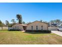 Attractive ranch-style home with a well-maintained lawn, complemented by lush greenery and mature trees at 1325 Fairlee St, Lakeland, FL 33813