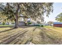 Large grassy backyard with a mature tree providing ample shade and privacy at 1495 Davis Ave, Bartow, FL 33830