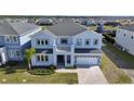 Two-story house, gray siding, two-car garage, and a landscaped yard at 171 Golden Noble St, Kissimmee, FL 34747