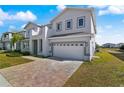 Two-story house with gray siding, a two-car garage, and a stone paved driveway at 171 Golden Noble St, Kissimmee, FL 34747