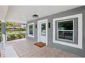 Inviting front porch featuring neutral-colored tile and two windows on each side of the front door at 20 N Lake Idylwild Dr, Winter Haven, FL 33881