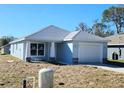 Newly built home features a light blue exterior, attached garage, and a well-maintained lawn at 2021 Alderman Rd, Auburndale, FL 33823