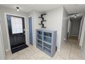 Bright entryway with tile flooring, storage cabinet, and shelving at 345 Piedmont Ct, Bartow, FL 33830