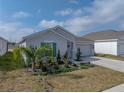 Well-maintained single-story home boasting a two-car garage, green shutters and manicured landscaping at 34575 Shellback St, Leesburg, FL 34788